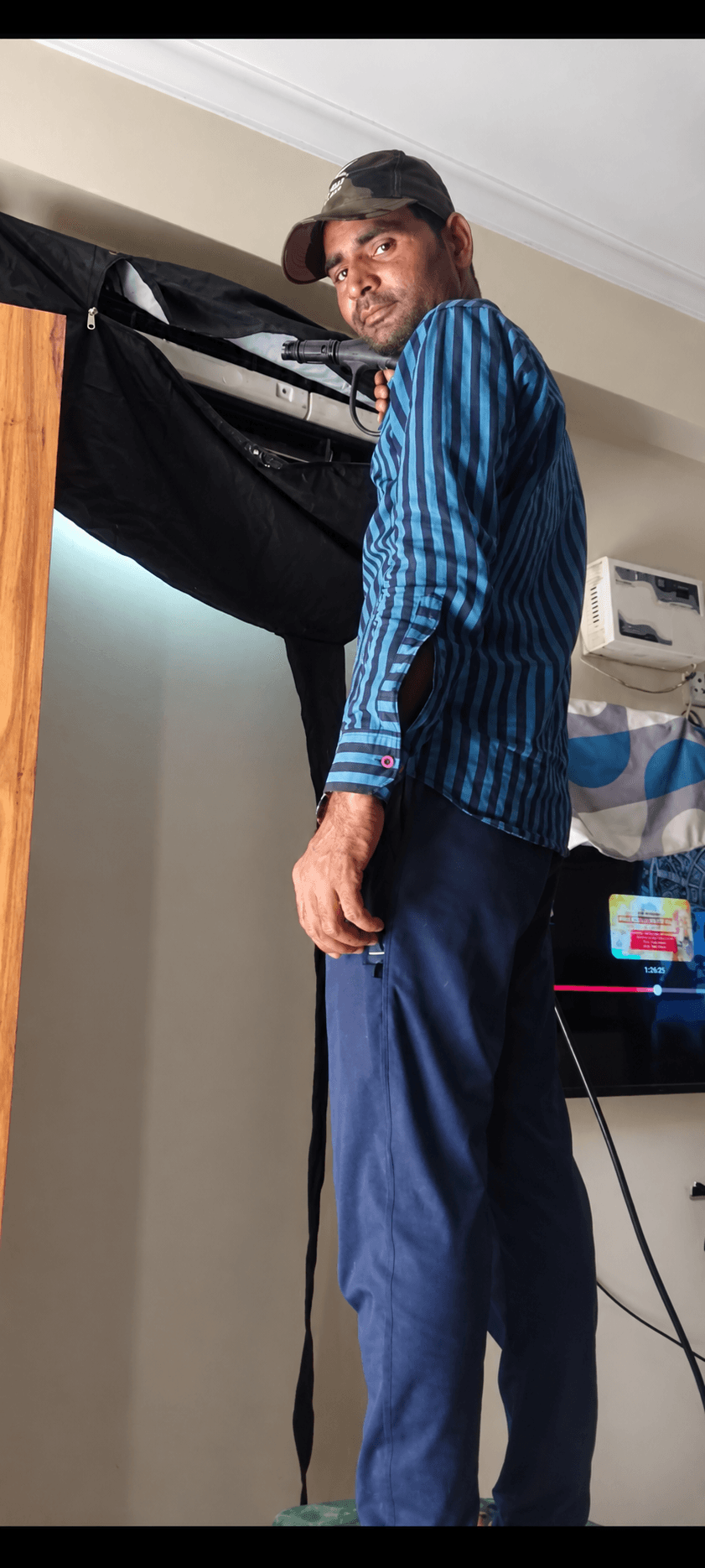 Our main technician beside a wall-mounted AC during a service visit