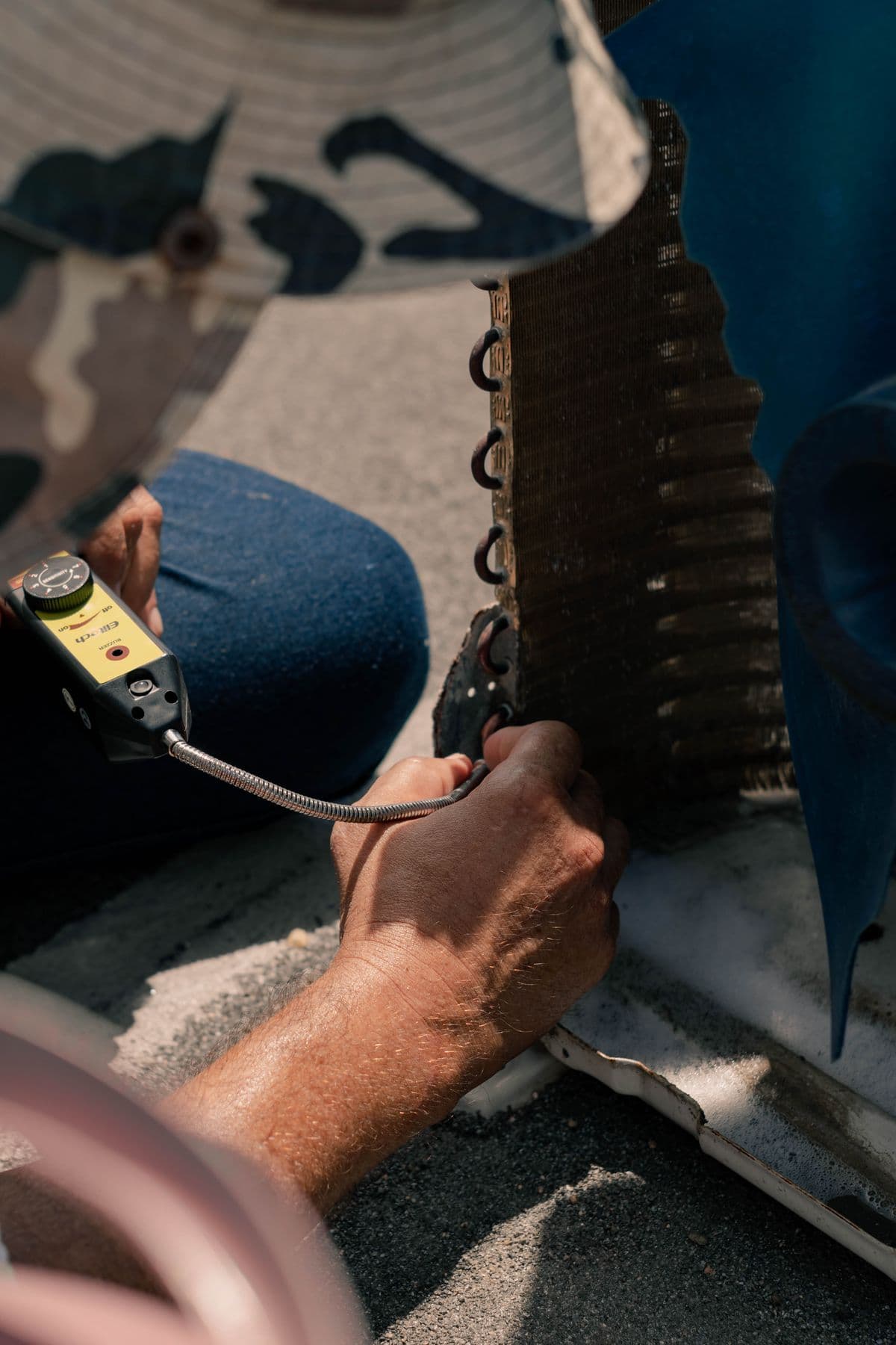 Technician checking an air conditioner coil with a diagnostic tool